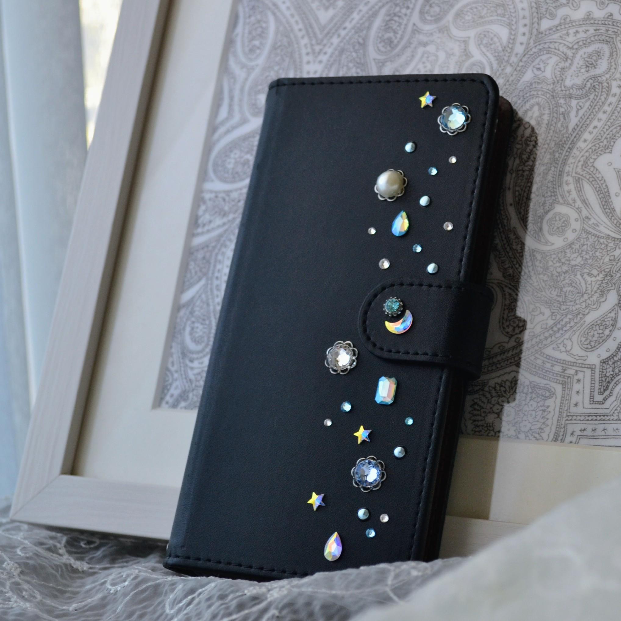 手帳型スマホケース『夜空のきらめき』水色とオーロラのクリスタル 漆黒のカバー　ほぼ全機種対応1枚目の画像